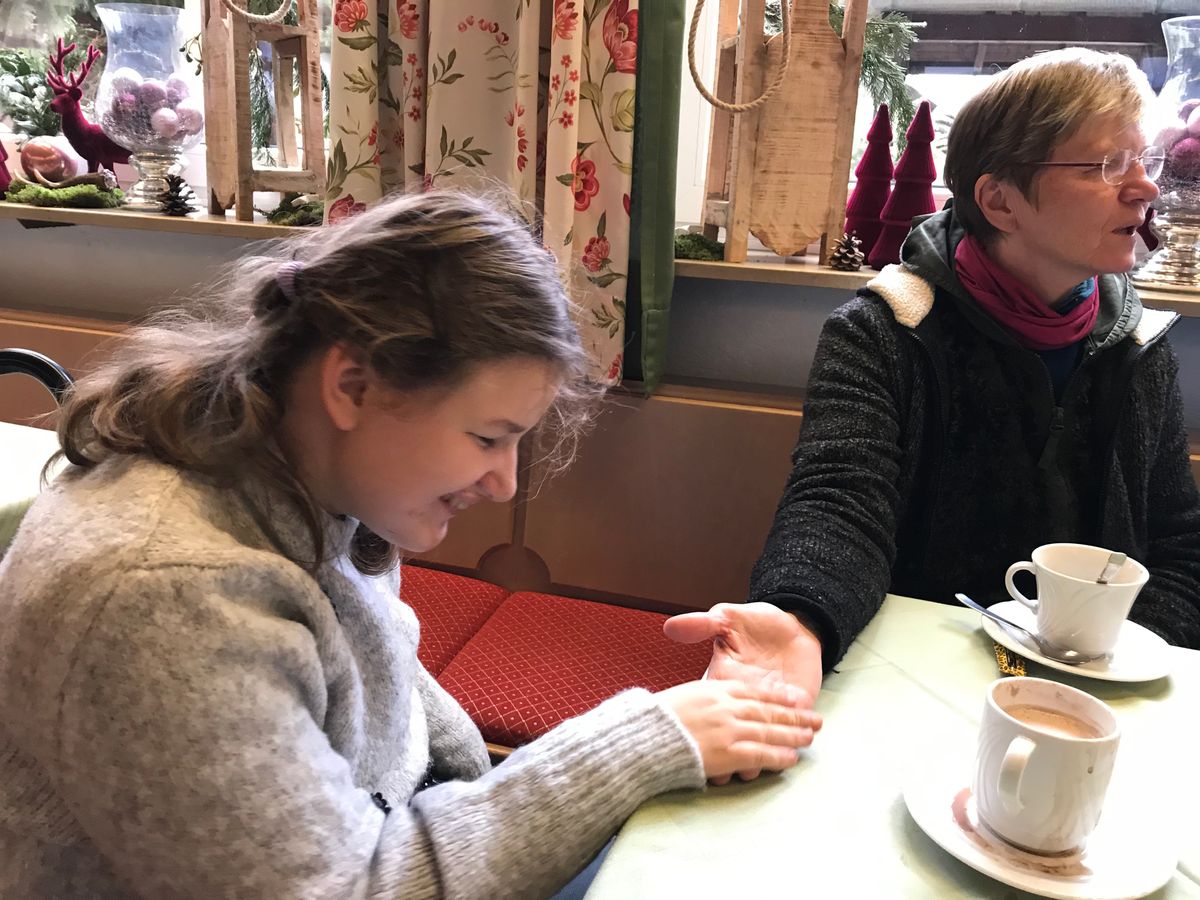 Alina im Cafes des Aura Hotels h&auml;lt die Hand von Johanna Riedmann im Jahr 2019